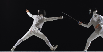 Na zdjęciu widać dwójkę ludzi walczących w szermierce